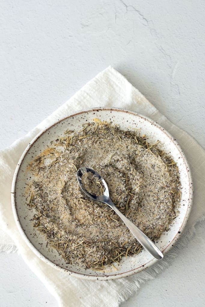 Plate of dry rub for turkey with a silver spoon.