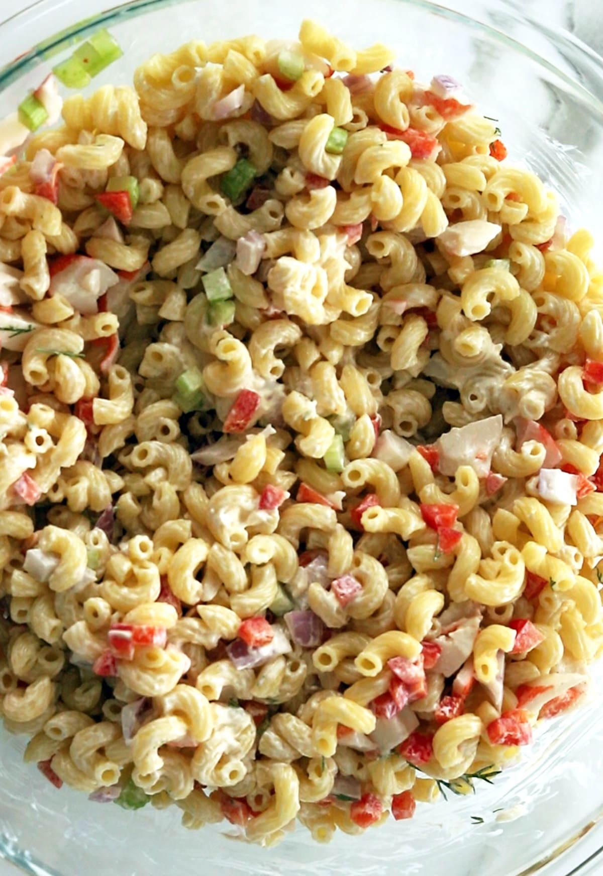 krab pasta salad in a clear mixing bowl.