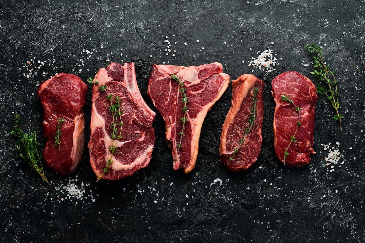 black board with the most tender cuts of beef raw on top.