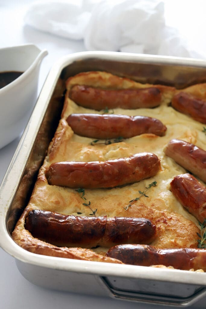 Silver baking tray with cooked toad in a hole.