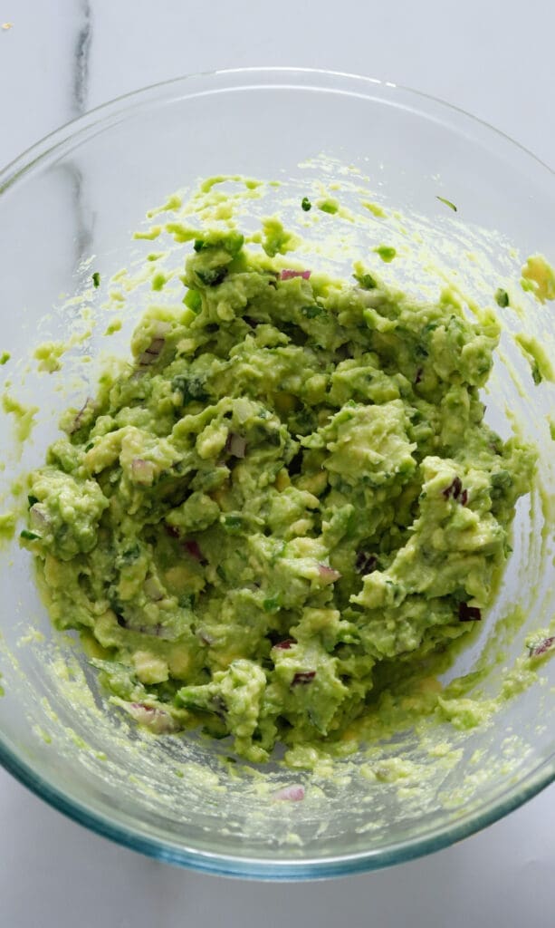 Clear bowl full of authentic guacamole.