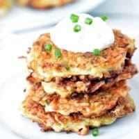 Zucchini Cakes stacked on a white plate.