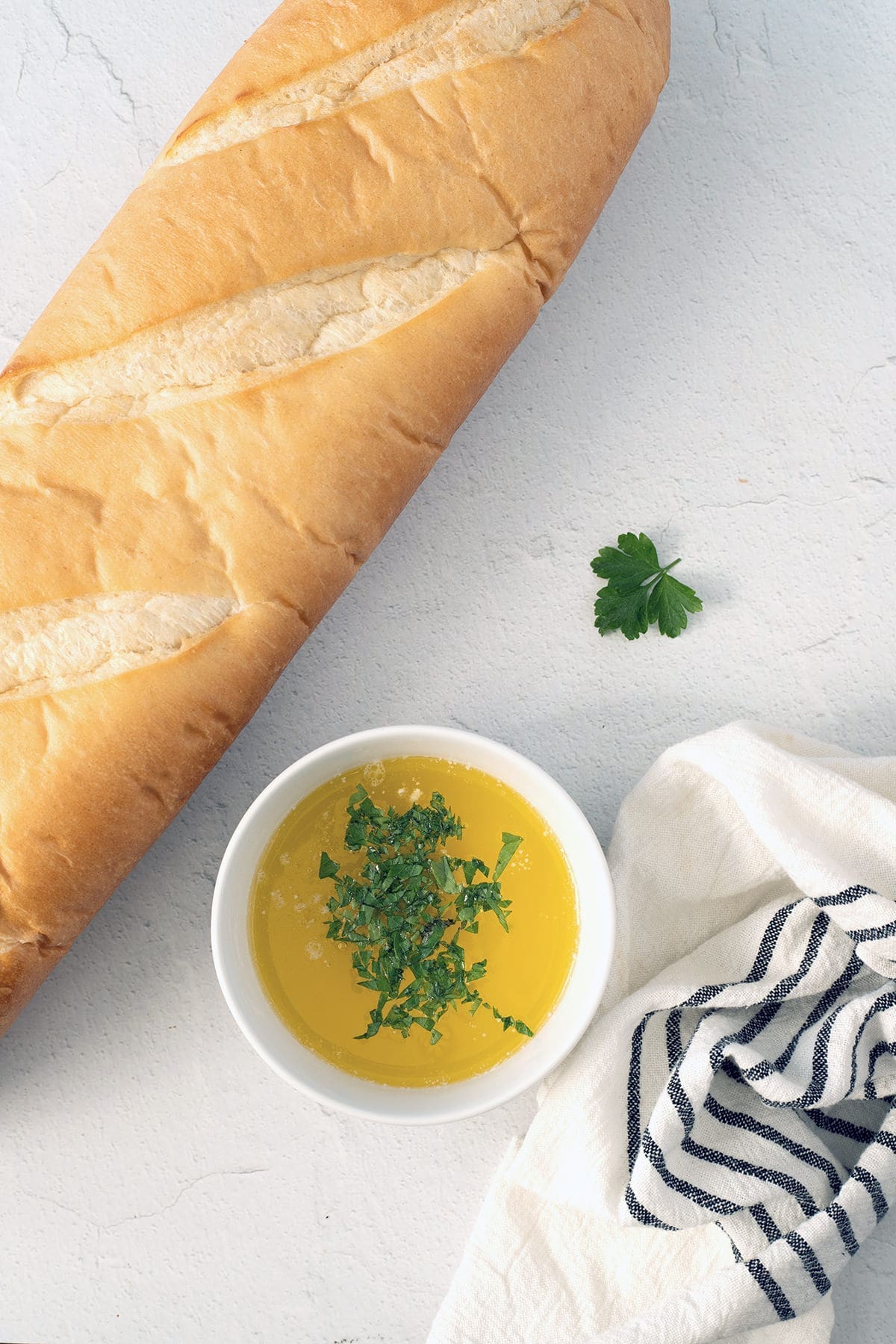 Loaf of bread next to garlic butter.