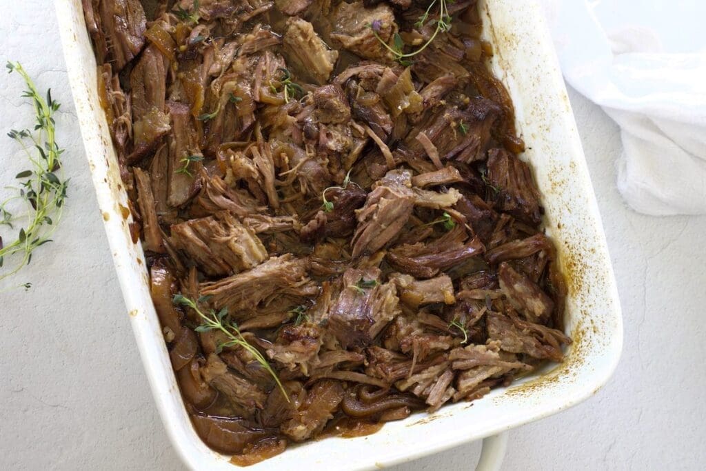 Shredded beef in a white baking sheet for "best cuts for shredded beef.