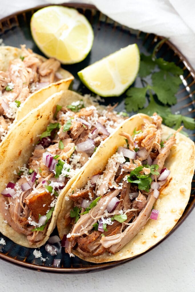 authentic pork carnitas tacos with cilantro and onion